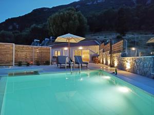 una piscina con due sedie e un ombrellone di Sea & Cliff Luxury Suites a Benitses