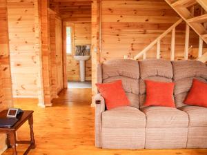 a living room with a couch in a log cabin at Callow Fold in Craven Arms