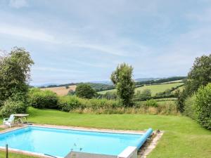 a swimming pool in a garden with a view at Callow Fold in Craven Arms