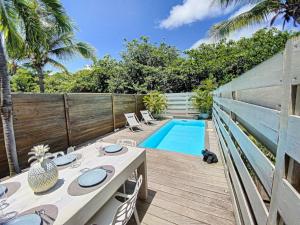a patio with a table and chairs next to a swimming pool at Villa Casalilo, Orient Bay in Orient Bay