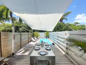 une terrasse avec une table et une piscine dans l'établissement Villa Casalilo, Orient Bay, à La Baie-Orientale
