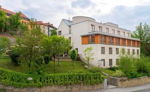 ein großes weißes Gebäude mit einem Garten davor in der Unterkunft Hotel Castle Garden in Budapest