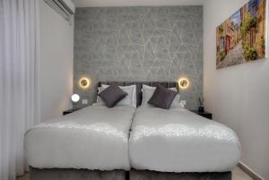 um quarto com uma grande cama branca e 2 almofadas em אחוזה בהרים em Meron