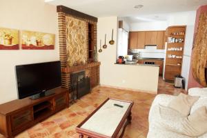 een woonkamer met een tv en een open haard bij Racó D Onil in Onil