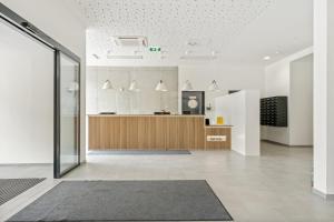 an office lobby with a reception desk and a glass door at SMARTments business Wien Heiligenstadt in Vienna