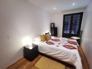 アヴェイロにあるRia de Aveiro Apartmentのベッドルーム1室(カラフルな毛布付きのベッド1台付)