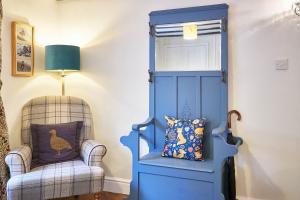 a blue door in a room with a chair and a lamp at Host & Stay - Willow Cottage in Helmsley +12 photos