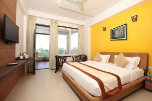 a bedroom with a large bed with a yellow wall at Genx Crescent Lucknow in Lucknow