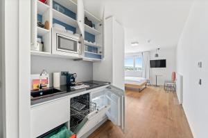 a kitchen with white cabinets and a sink at SMARTments business Wien Heiligenstadt in Vienna