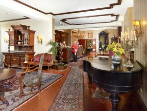 ein Wohnzimmer mit Möbeln und einem Klavier in der Unterkunft Schloßhotel Kurfürstliches Amtshaus Dauner Burg in Daun