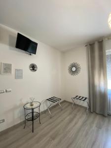 a room with two chairs and a table and a tv at B&B LA CORTE di TIZIANA in San Giovanni Lupatoto