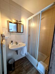 a bathroom with a sink and a shower at Pension Villaggio in Mertesheim