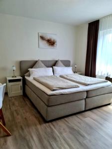 ein Schlafzimmer mit einem großen Bett in einem Zimmer in der Unterkunft Pension Villaggio in Mertesheim