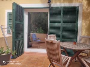 a patio with a table and chairs and a sliding glass door at Menorca beach in Cala Galdana
