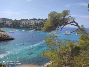 a group of boats in a body of water at Menorca beach in Cala Galdana