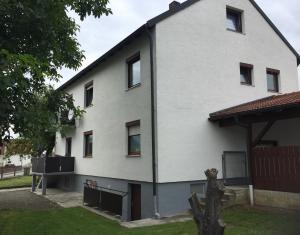 uma casa branca com um telhado de gambrel em Komfort Wohn- und Ferienhaus JAKOBI em Reichertshofen