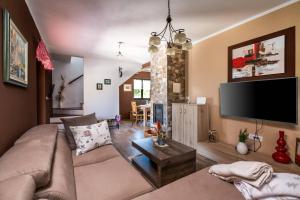 ein Wohnzimmer mit einem Sofa und einem Flachbild-TV in der Unterkunft Villa Madonnina in Manjadvorci
