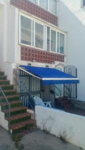 eine blaue Markise an der Seite eines Gebäudes in der Unterkunft Roses, Puig Rom in Roses