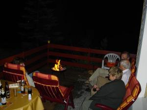 eine Gruppe von Menschen, die um eine Feuerstelle herum sitzen in der Unterkunft Haus Brockenblick in Gehlberg