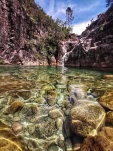 a river in a canyon with rocks in the water at Casa da Cuca in Campo do Gerês