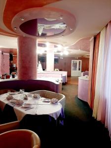 a dining room with two tables with white tablecloths at Hotel Vetraz in Vitebsk