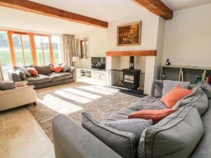 a living room with two couches and a fireplace at Church Barn in North Tawton