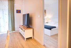 Schlafzimmer mit einem TV, einem Bett und einem Spiegel in der Unterkunft Firpo: Cozy double room city centre apartment in Vis
