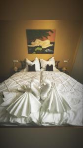 Cama blanca con sábanas y almohadas blancas en Mainsommer, en Kemmern