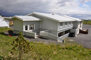 a large white house in a parking lot at The Vík Inn by Ourhotels in Vík
