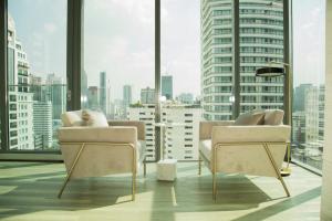 un soggiorno con due sedie e una grande finestra di Sukhumvit 11#Luxury#Pool#Gym#BTS Nana&MRT Sukhumvit#1BR#Max4ppl a Bangkok