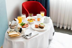 a table with breakfast food on it with a red chair at Radisson Blu Hotel, Kyiv Podil City Centre in Kyiv