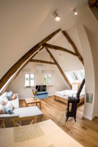 uma sala de estar com um sótão com um sofá e uma cama em Zum Heuerling Ferienwohung Leinenstube mit Sauna em Versmold