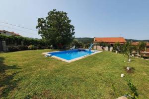 a large yard with a swimming pool in the grass at Apartamento A Fontiña in Pontevedra