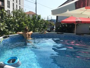 een vrouw zit in een zwembad bij Mantarini Hotel in Adler