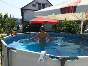 een vrouw staat in een zwembad bij Mantarini Hotel in Adler