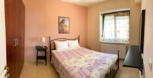 a small bedroom with a bed and a window at Hawaii in Nea Michaniona