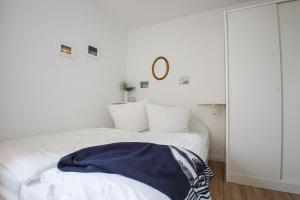 two beds in a white room with a blue blanket on it at Haus Uthlande Uthlande Whg 32 Sonnendeck in Wyk auf Föhr