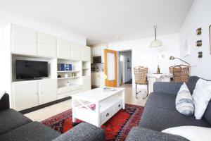 Una sala de estar con un sofá y un televisor. en Haus Uthlande Uthlande Whg 22 Seeluft, en Wyk auf Föhr