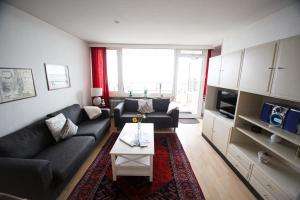 una sala de estar con un sofá y una mesa en Haus Uthlande Uthlande Whg 22 Seeluft, en Wyk auf Föhr