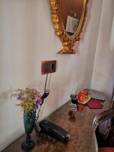 a table with a phone and a vase of flowers and a mirror at La Llave de la Judería Hotel Boutique in Córdoba