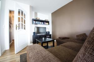 ein Wohnzimmer mit einem Sofa und einem TV in der Unterkunft Haus Uthlande Uthlande Whg 52 Möwennest in Wyk auf Föhr