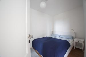 a small bedroom with a bed with blue sheets at Oland Whg 13 Seestern in Wyk auf Föhr +14 photos