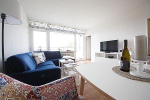 a living room with a blue couch and a table at Oland Whg 13 Seestern in Wyk auf Föhr