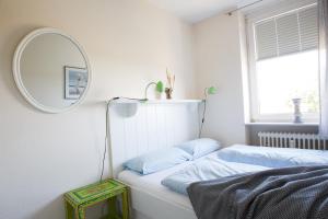 a bedroom with a mirror and a bed with blue pillows at Oland Whg 14 Nordseetraum in Wyk auf Föhr