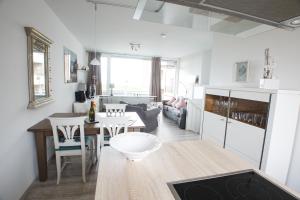 a kitchen and living room with a table and chairs at Langeneß Whg 5 Sonneninsel in Wyk auf Föhr