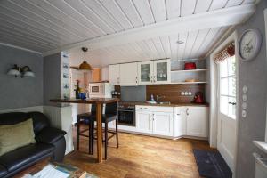 a kitchen with white cabinets and a table in a room at Luv in Oevenum