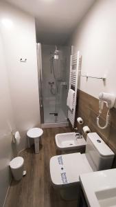 a bathroom with a toilet sink and a shower at Hotel Balneario El Raposo in Puebla de Sancho Pérez
