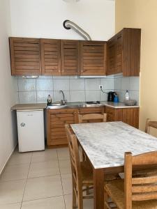 a kitchen with wooden cabinets and a table with chairs at Kryoneri village in Kryonéri