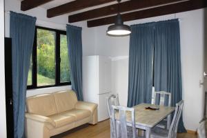 a living room with a couch and a table at Borjomi Cottage Sadgeri in Sadgeri +14 photos