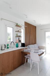 una cucina con tavolo, sedie e lavandino di Corfu Garden Villas a Città di Corfù